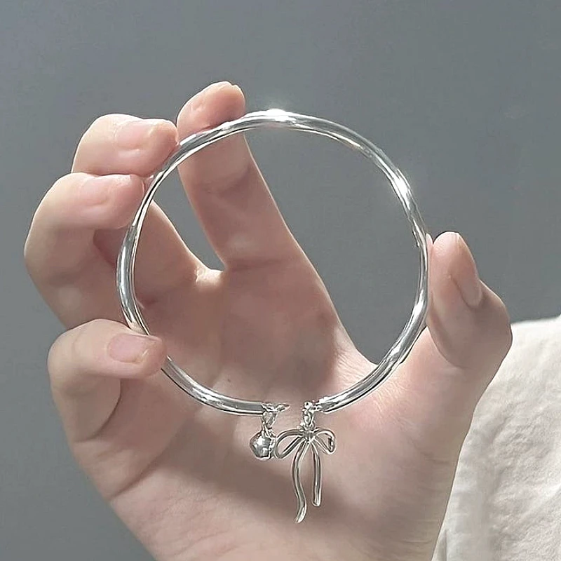 Silver-Tone Bow Ribbon &amp; Bell Charm Rigid Bangle 